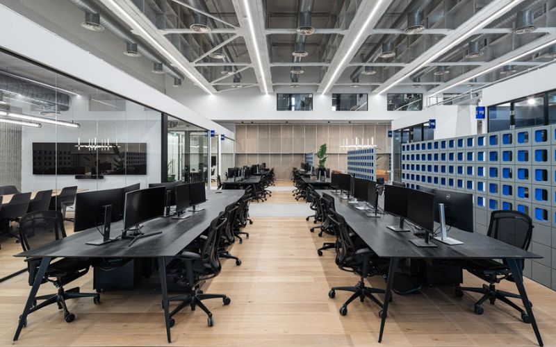 Mẫu thiết kế văn phòng mở phong cách Industrial với trần hở và sử dụng nội thất tông đen hiện đại